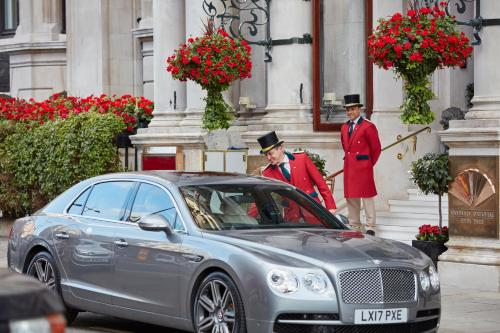 two men standing next to a car in front of a building at Mandarin Oriental Hyde Park, London in London