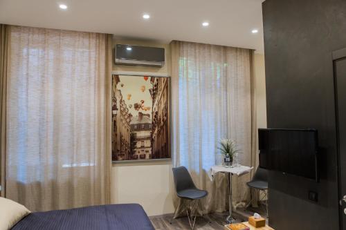 Un dormitorio con una cama, un televisor y una mesa. en Malon apartments, en Odessa