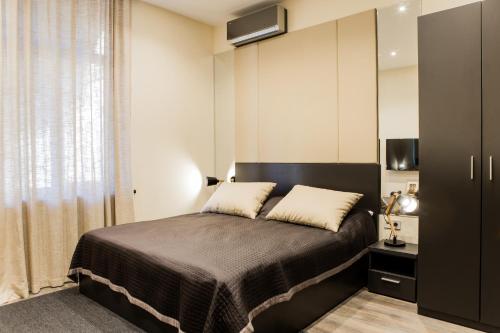 a bedroom with a large bed and a cabinet at Malon apartments in Odesa
