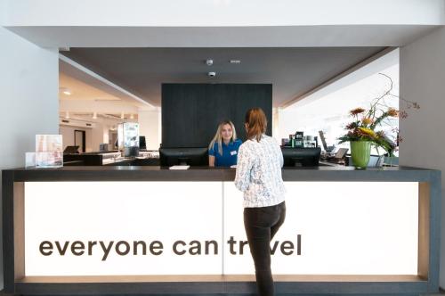 two women standing at a counter in an office at a&o Bremen Hauptbahnhof in Bremen