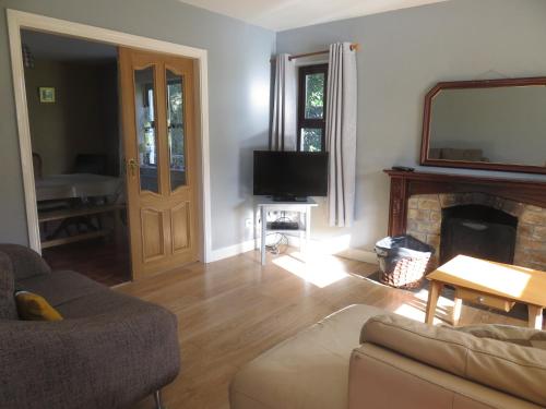 a living room with a couch and a fireplace at BunkHouse - Letterfrack Farm in Letterfrack