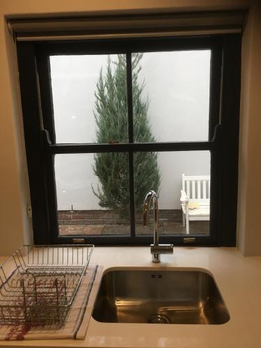 a kitchen window with a sink and a christmas tree at Blueberry Hill Cottages in Franschhoek