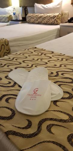 a white hat on the bed of a hotel room at Grand Zeybek Hotel in Izmir