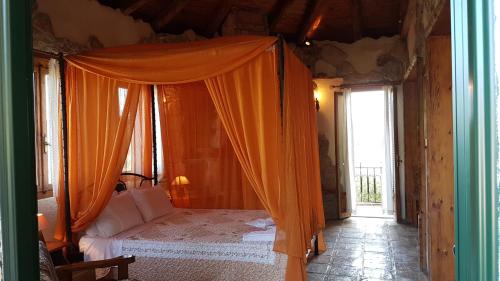 a bedroom with a bed with an orange canopy at Castello Bellos Tower in Keri