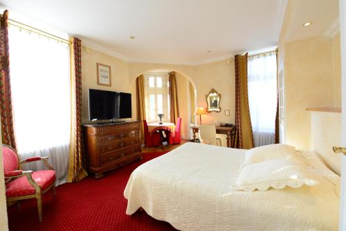 a bedroom with a bed and a flat screen tv at Hotel De l'Europe Basel Mulhouse Airport in Saint-Louis