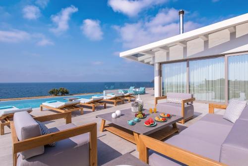 パノルモス・レティムノにあるThalassa Residence, a luxury coastal escape, By ThinkVillaの海の景色を望むパティオ