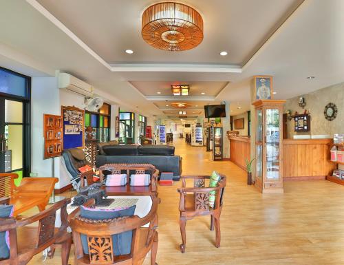 a living room with a couch and tables and chairs at Boonme Heritage in Phitsanulok