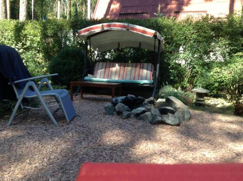 a backyard with a chair and a table and an umbrella at Domik v lesy in Lyutezh