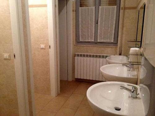 a bathroom with two sinks and a mirror at Ostello Angolo Verde in Angolo Terme