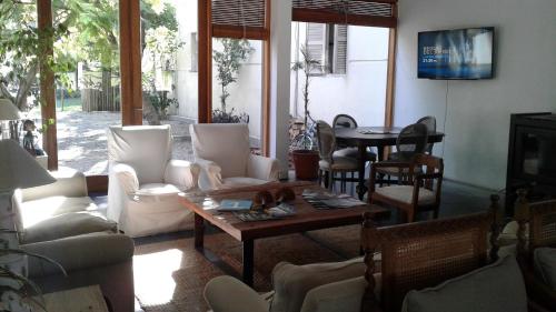 a living room with white furniture and a table at Hotel Boutique Casagrande in Paysandú