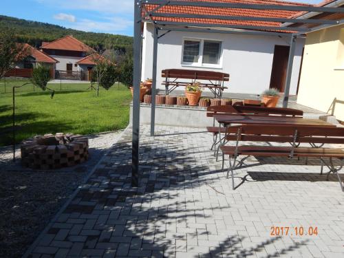 a group of tables and benches on a patio at Tündér Szálló Eplény in Eplény
