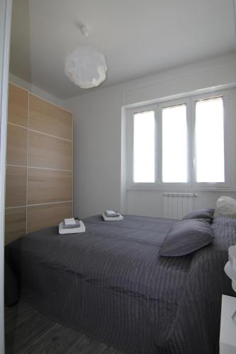 ein Schlafzimmer mit einem großen Bett und zwei Fenstern in der Unterkunft Appartamento Zona Torregalli_Nuvola Rossa in Florenz