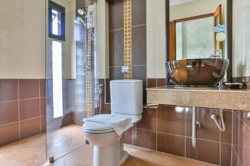 ein Badezimmer mit Toilette und Waschbecken in der Unterkunft Boonme Heritage in Phitsanulok