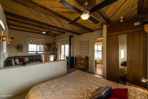 a bedroom with a bed and a ceiling fan at Arava Land in Zuqim