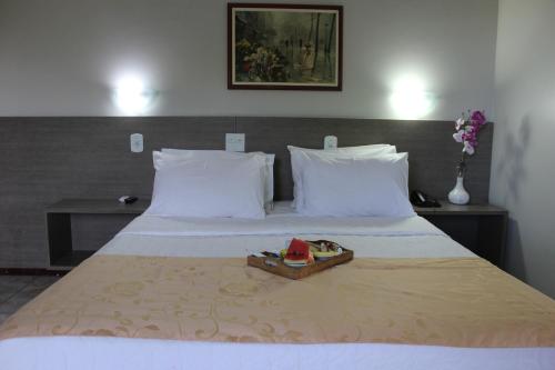 Una cama en una habitación de hotel con una bandeja. en Solar das Mangueiras, en Barreiras