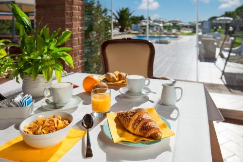 a table with a breakfast of croissants and orange juice at Fattoria Maremmana in Marina di Grosseto