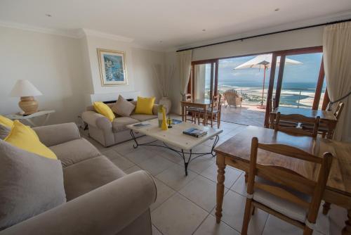a living room with a couch and a table at La Vista Lodge in Plettenberg Bay