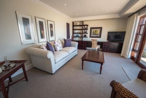 a living room with a couch and a tv at La Vista Lodge in Plettenberg Bay