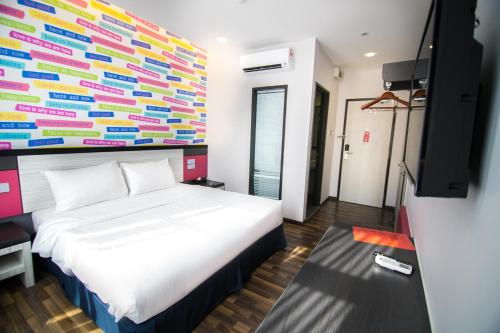 a bedroom with a bed and a colorful wall at INDRA HOTEL - BOUTIQUE SUITES in Ipoh