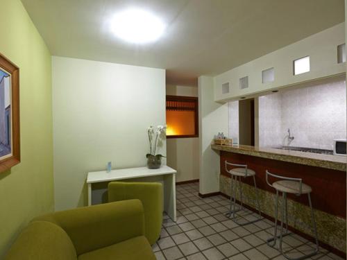 uma cozinha com um sofá e cadeiras num quarto em Flat praia Vila Velha ES em Vila Velha