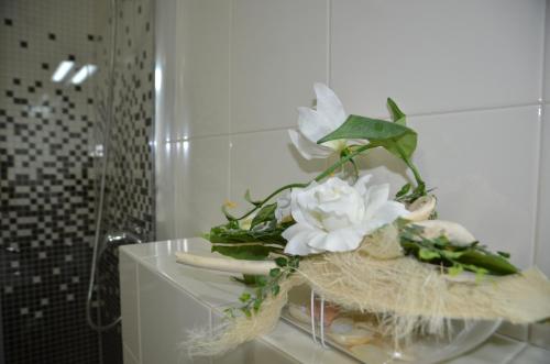 a vase with white flowers on a table in a bathroom at Chata Patúch in Babkov