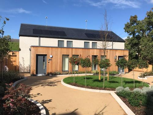 a house with a gambrel roof and a driveway at Beech House - Urban Apartments in Bristol