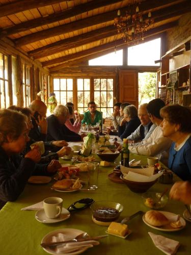 a group of people sitting at a table eating food at Cabañas Puente Negro in Puente Negro