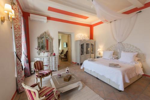 1 dormitorio con 1 cama blanca y 1 silla en Gite des Carmes and Spa, en Le Thor