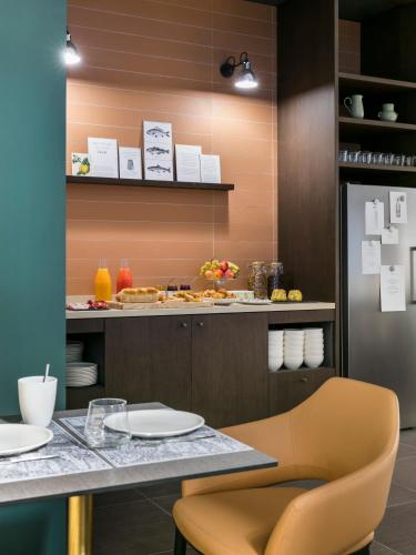 a kitchen with a counter and a table with plates at OKKO Hotels Strasbourg Centre in Strasbourg