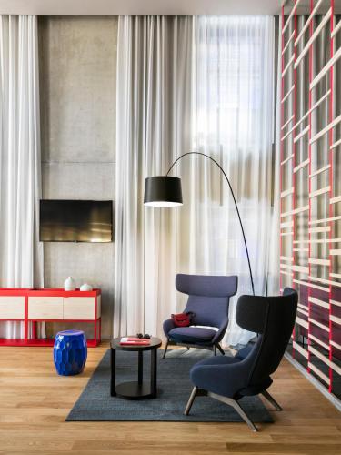 a living room with a chair and a lamp at OKKO Hotels Strasbourg Centre in Strasbourg