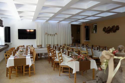a banquet hall with white tables and chairs with flowers at Chata Patúch in Babkov