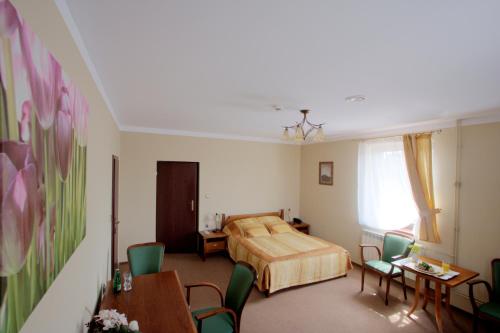 a bedroom with a bed and a table and chairs at Resort Jura in Kroczyce