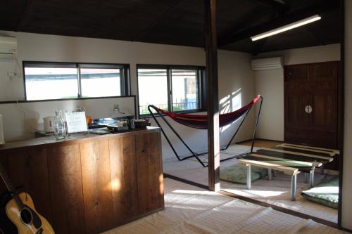 a room with a hammock in the middle of a room at Guest House Yukari in Tsuru 