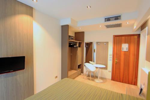 a bedroom with a bed and a desk and a tv at Hotel Ideal in Sirmione