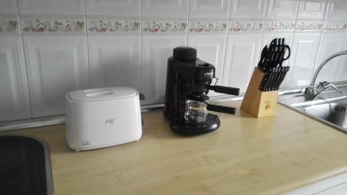 a coffee maker on a kitchen counter next to a sink at Apartamento junto al Duero en la Sierra de Urbión in Molinos de Duero