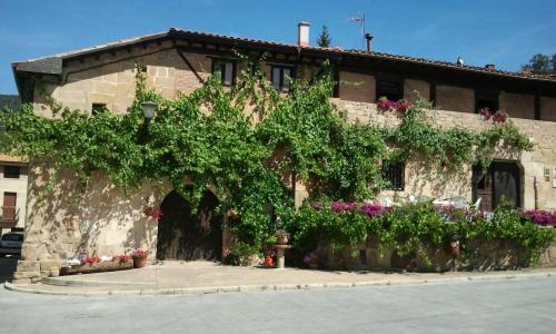 a building with a bunch of flowers in front of it at Apartamento junto al Duero en la Sierra de Urbión in Molinos de Duero
