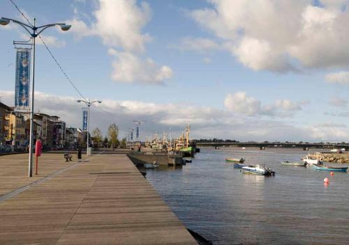 a river with boats docked next to a pier at Faythe Holiday Home Wexford Town in Wexford