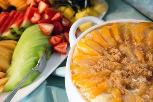 um prato de frutas com uma tigela de frutas com molho em The Kenwood Inn Oldest Bed and Breakfast, St Augustine Historic District em St. Augustine