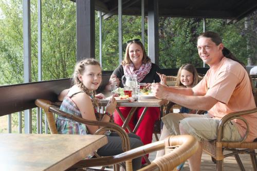 un grupo de personas sentadas en una mesa comiendo comida en Hellmut-Waßmer-Jugendherberge Lörrach, en Lörrach