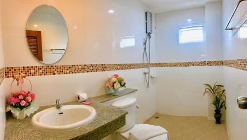La salle de bains est pourvue d'un lavabo, de toilettes et d'un miroir. dans l'établissement J Apartment, à Ao Nang Beach