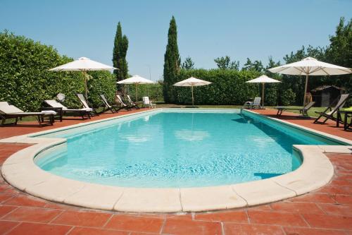 a swimming pool with chairs and umbrellas at I Costanti in Caldiero