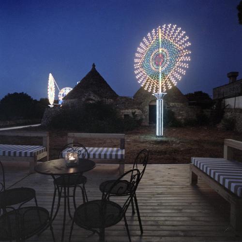 a patio with a table and chairs and a ferris wheel at Borgo trulli 1789 in Ostuni