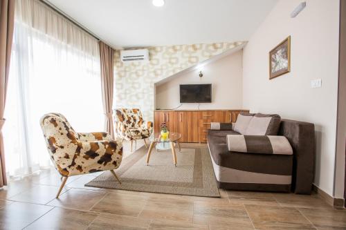 a living room with a couch and two chairs at Apartmani MG in Nikšić