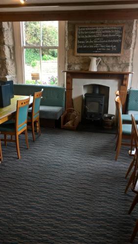 a room with a table and chairs and a fireplace at The Badger Inn in Carbis Bay