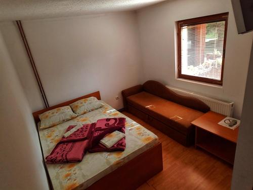 a small bedroom with a bed and a couch at Guesthouse Ramović in Zlatibor