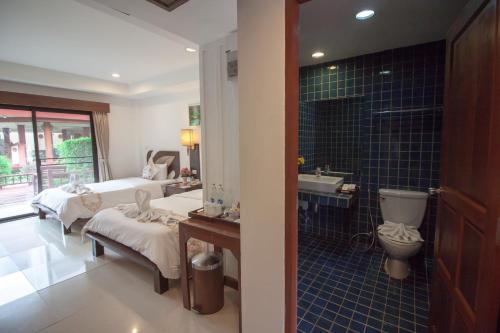 a bathroom with two beds and a sink and a toilet at The Privacy Beach Resort & Spa in Sam Roi Yot