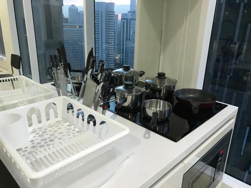 Soho Suites Klcc By Pnut KLCC VIEW في كوالالمبور: مطبخ مع طاولة مع الأواني والمقالي