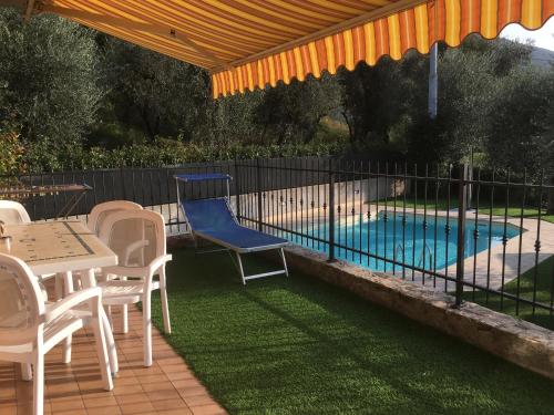 a patio with a table and chairs and a swimming pool at Mary Apartments in Brenzone sul Garda