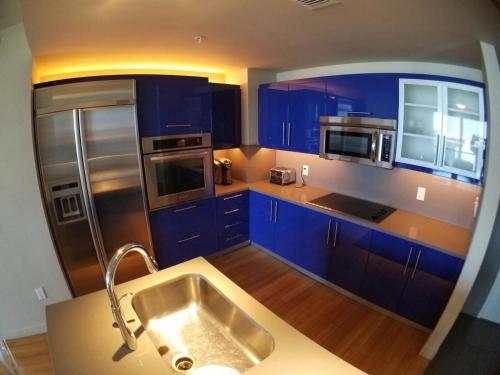 a kitchen with blue cabinets and a stainless steel refrigerator at 2 BR W Residences Ft. Lauderdale in Fort Lauderdale