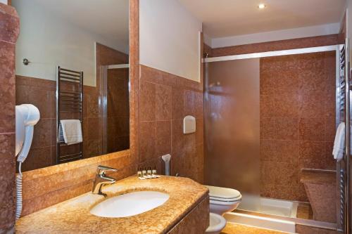 y baño con lavabo, aseo y ducha. en B&B Hotel Padova, en Padua